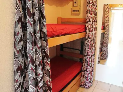 a small room with a bunk bed with curtains at Studio cosy avec balcon à Samoëns, parking inclus, pour 4 pers. - FR-1-815-114 in Samoëns