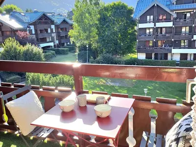 a table on a balcony with a view of a building at Studio cosy avec balcon à Samoëns, parking inclus, pour 4 pers. - FR-1-815-114 in Samoëns