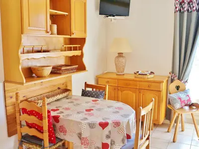 a dining room with a table and a tv at Studio cosy avec balcon à Samoëns, parking inclus, pour 4 pers. - FR-1-815-114 in Samoëns
