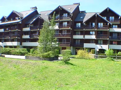 a large apartment building with a green field in front of it at Studio cosy avec balcon à Samoëns, parking inclus, pour 4 pers. - FR-1-815-114 in Samoëns