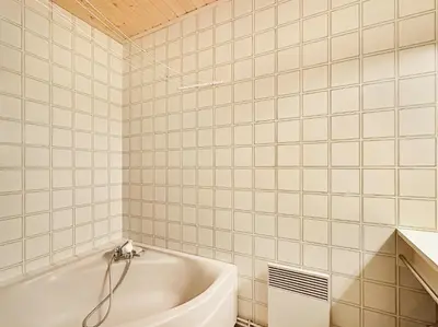 a white tiled bathroom with a bath tub at ES117 - Duplex 6 pers pied de pistes in Les Carroz d'Araches