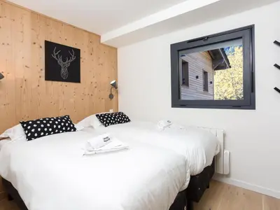 two beds in a room with a window at Apartment La Cordee 504 mit Terrasse by Interhome in Chamonix-Mont-Blanc