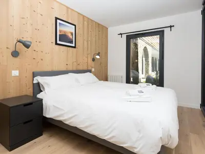 a bedroom with a large white bed and a window at Apartment La Cordee 504 mit Terrasse by Interhome in Chamonix-Mont-Blanc