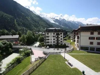 a view of a building with mountains in the background at Apartment Charmante Wohnung in Chamonix mit Südbalkon und Blick auf den Blanc by Interhome in Chamonix-Mont-Blanc