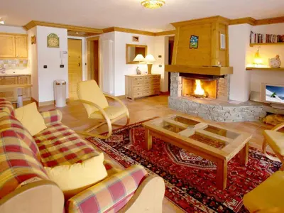 a living room with a fireplace and a couch at Apartment Charmante Wohnung in Chamonix mit Südbalkon und Blick auf den Blanc by Interhome in Chamonix-Mont-Blanc