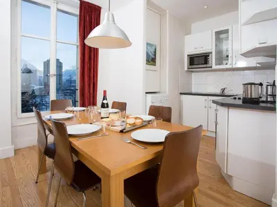 a kitchen with a wooden table with chairs and a dining room at Apartment Wohnung in Chamonix by Interhome in Chamonix-Mont-Blanc