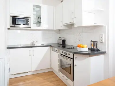 a kitchen with white cabinets and a bowl of fruit on the counter at Apartment Wohnung in Chamonix by Interhome in Chamonix-Mont-Blanc
