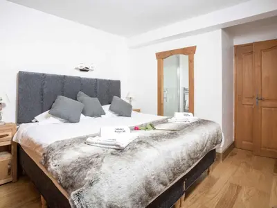 a bedroom with a large bed with a gray headboard at Apartment Ginabelle 8 Wohnung by Interhome in Chamonix-Mont-Blanc