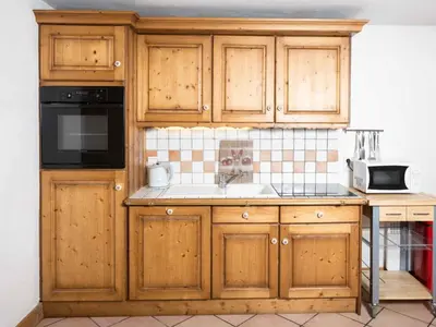 a kitchen with wooden cabinets and a sink at Apartment Ginabelle 8 Wohnung by Interhome in Chamonix-Mont-Blanc
