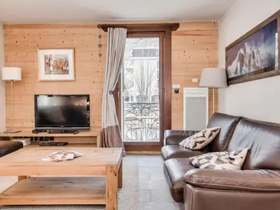 a living room with a couch and a tv at Apartment Wohnung in Chamonix mit sonnigem Balkon und toller Aussicht by Interhome in Chamonix-Mont-Blanc