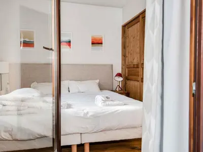 a bedroom with a white bed with a glass door at Apartment Wohnung in Chamonix mit sonnigem Balkon und toller Aussicht by Interhome in Chamonix-Mont-Blanc