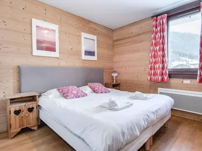 a bedroom with a large bed in a room with wooden walls at Apartment Wohnung in Chamonix mit sonnigem Balkon und toller Aussicht by Interhome in Chamonix-Mont-Blanc