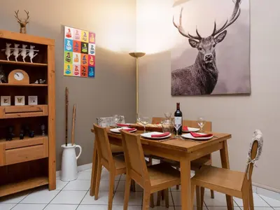 a dining room with a table with a deer painting on the wall at Apartment in Chamonix und Bergblick by Interhome in Chamonix-Mont-Blanc