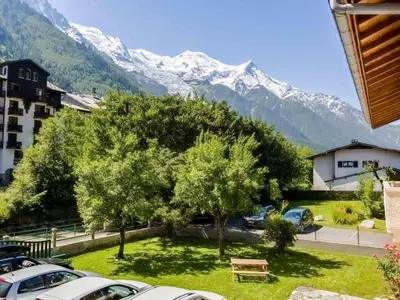 a parking lot with cars parked in front of a mountain at Apartment Komfortable Wohnung in Chamonix mit Südterrasse by Interhome in Chamonix-Mont-Blanc