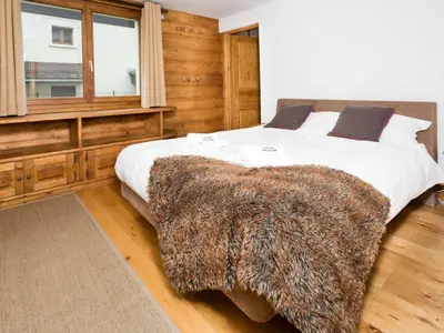 a bedroom with a large bed with a furry blanket on it at Apartment Komfortable Wohnung in Chamonix mit Südterrasse by Interhome in Chamonix-Mont-Blanc
