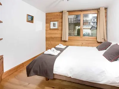 a bedroom with a white bed and a window at Apartment Komfortable Wohnung in Chamonix mit Südterrasse by Interhome in Chamonix-Mont-Blanc