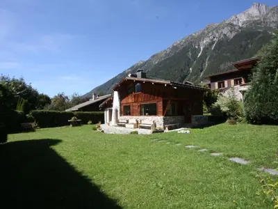 a house in the mountains with a green lawn at Holiday Home Chalet Martinique by Interhome in Chamonix-Mont-Blanc