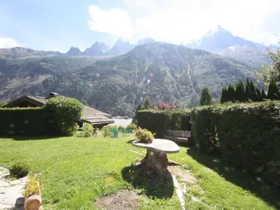 a bench in a yard with a view of mountains at Holiday Home Chalet Martinique by Interhome in Chamonix-Mont-Blanc