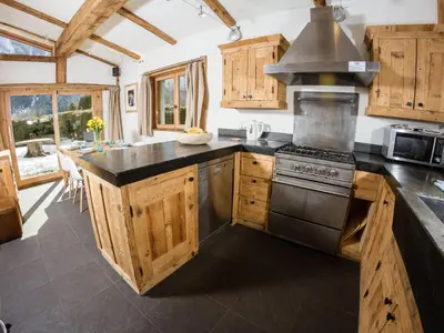 a kitchen with wooden cabinets and a stove at Holiday Home Chalet Martinique by Interhome in Chamonix-Mont-Blanc