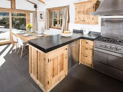 a kitchen with wooden cabinets and a black counter top at Holiday Home Chalet Martinique by Interhome in Chamonix-Mont-Blanc