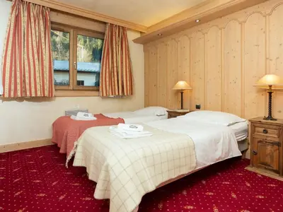 two beds in a hotel room with red carpet at Apartment Chamois Apartment by Interhome in Chamonix-Mont-Blanc