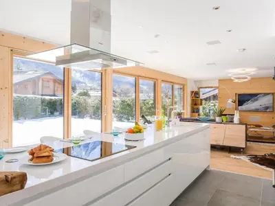 a kitchen with white cabinets and a large window at Holiday Home Chalet Montana by Interhome in Chamonix-Mont-Blanc