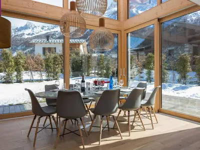a dining room with a table and chairs in front of windows at Holiday Home Chalet Montana by Interhome in Chamonix-Mont-Blanc