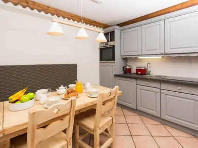 a kitchen with a wooden table with fruit on it at Apartment in Chamonix mit geräumigem Balkon und weitem Blick by Interhome in Chamonix-Mont-Blanc