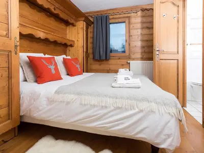 a bedroom with a large bed with red pillows at Apartment in Chamonix mit geräumigem Balkon und weitem Blick by Interhome in Chamonix-Mont-Blanc