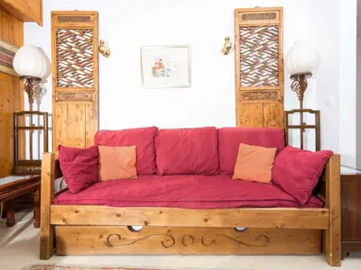 a wooden couch with red cushions in a room at Apartment Le Brevent Wohnung by Interhome in Chamonix-Mont-Blanc