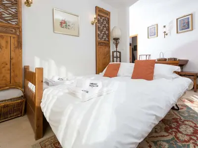 a bedroom with a large bed with white sheets at Apartment Le Brevent Wohnung by Interhome in Chamonix-Mont-Blanc
