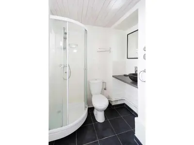 a white bathroom with a shower and a toilet at Apartment Wohnung in Chamonix Centre-Ville und Bergblick by Interhome in Chamonix-Mont-Blanc