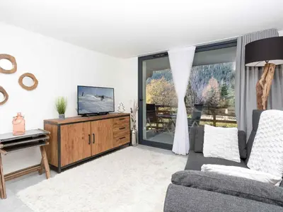 a living room with a couch and a television and a piano at Apartment La Cordee 412 mit Balkon by Interhome in Chamonix-Mont-Blanc