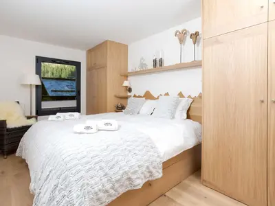 a bedroom with a large white bed and a window at Apartment La Cordee 412 mit Balkon by Interhome in Chamonix-Mont-Blanc