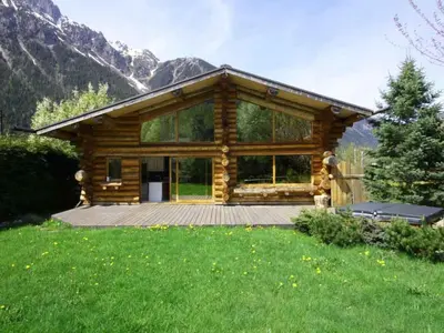 a log cabin with a deck in the grass at Holiday Home für 10 Personen in Chaonix-Mont-Blanc- Französische Alpen - Savoyer Alpen by Interhome in Chamonix-Mont-Blanc