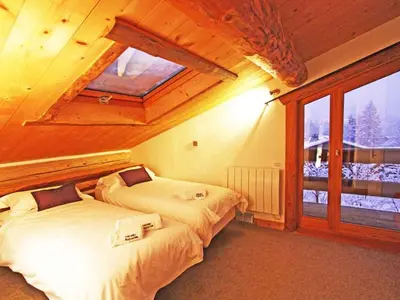 two beds in a room with a window at Holiday Home für 10 Personen in Chaonix-Mont-Blanc- Französische Alpen - Savoyer Alpen by Interhome in Chamonix-Mont-Blanc