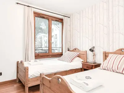 two beds in a room with a window at Apartment Balmat Wohnung by Interhome in Chamonix-Mont-Blanc