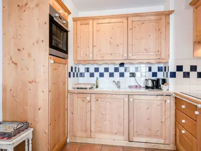 a kitchen with wooden cabinets and a sink at Apartment Balmat Wohnung by Interhome in Chamonix-Mont-Blanc