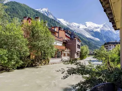 a river in a town with mountains in the background at Apartment Lou Lou Apartment by Interhome in Chamonix-Mont-Blanc