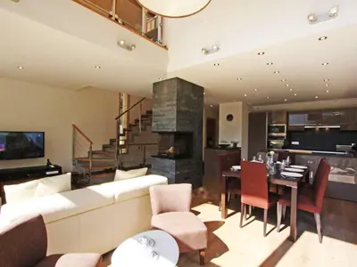 a living room with a couch and a dining room at Holiday Home Hütte Raphael by Interhome in Chamonix-Mont-Blanc