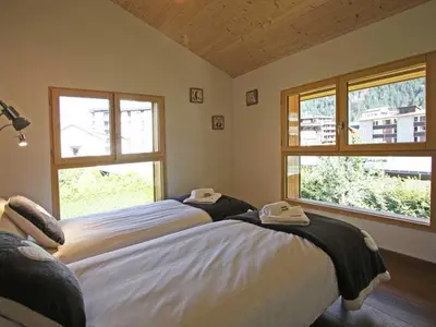 two beds in a room with two windows at Holiday Home Hütte Raphael by Interhome in Chamonix-Mont-Blanc