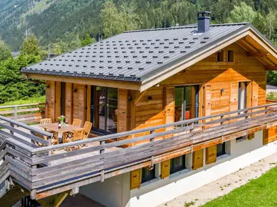 a log cabin with a table on the deck at Holiday Home Chalet de l'Ours - Bärenhütte by Interhome in Chamonix-Mont-Blanc