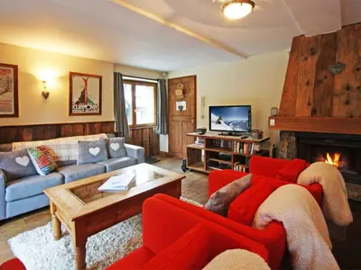 a living room with a red couch and a fireplace at Apartment La Ferme des Praz Appt by Interhome in Chamonix-Mont-Blanc