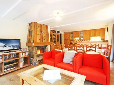 a living room with two red chairs and a fireplace at Apartment La Ferme des Praz Appt by Interhome in Chamonix-Mont-Blanc