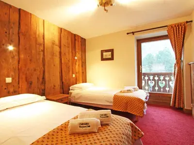 a hotel room with two beds and a window at Apartment La Ferme des Praz Appt by Interhome in Chamonix-Mont-Blanc