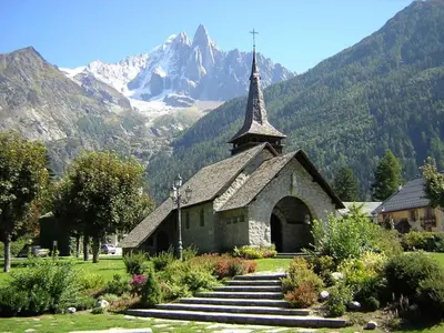 a church with a mountain in the background at Apartment La Ferme des Praz Appt by Interhome in Chamonix-Mont-Blanc