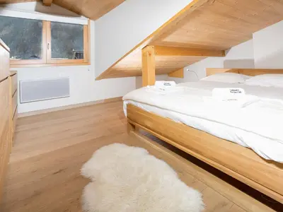 a bedroom with a large bed and a white rug at Apartment Wohnung Sauberands 18 mit Balkon by Interhome in Chamonix-Mont-Blanc