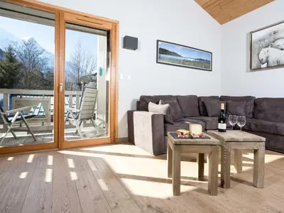 a living room with a couch and a table with wine glasses at Apartment Wohnung Sauberands 18 mit Balkon by Interhome in Chamonix-Mont-Blanc