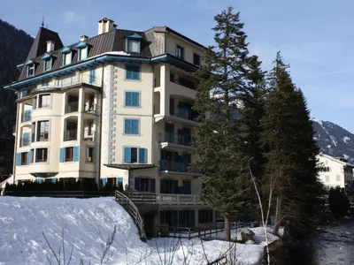 a large building in the snow next to a tree at Apartment Apothekerwohnung by Interhome in Chamonix-Mont-Blanc