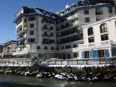 a large white building next to a river at Apartment Apothekerwohnung by Interhome in Chamonix-Mont-Blanc